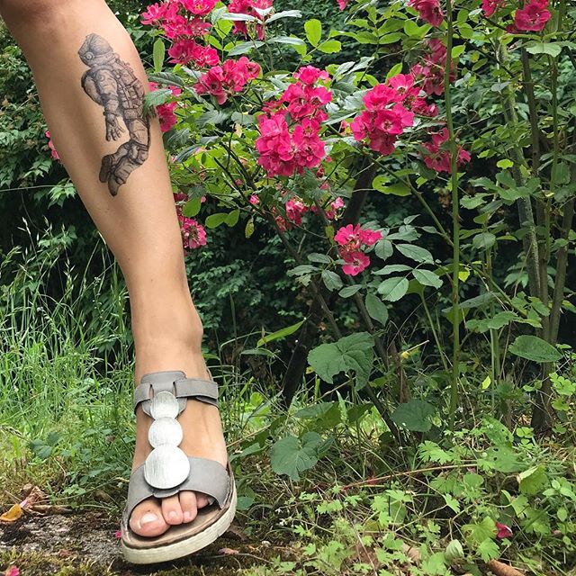 Jambe tatouée de la jardinière à côté de fleurs