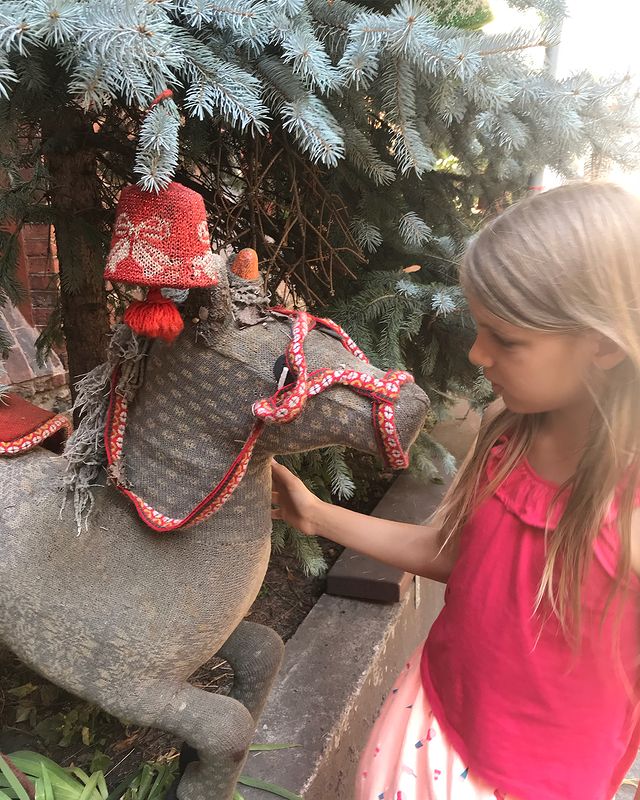 Petite fille et statue de cheval décoré