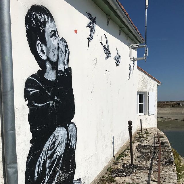 Street art d'un enfant qui imite le bruit des oiseaux sauf que les oiseaux sont des poissons volants