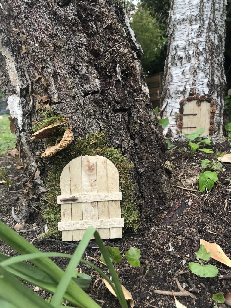 mini-porte de fée ou de lutin au pied d'un arbre