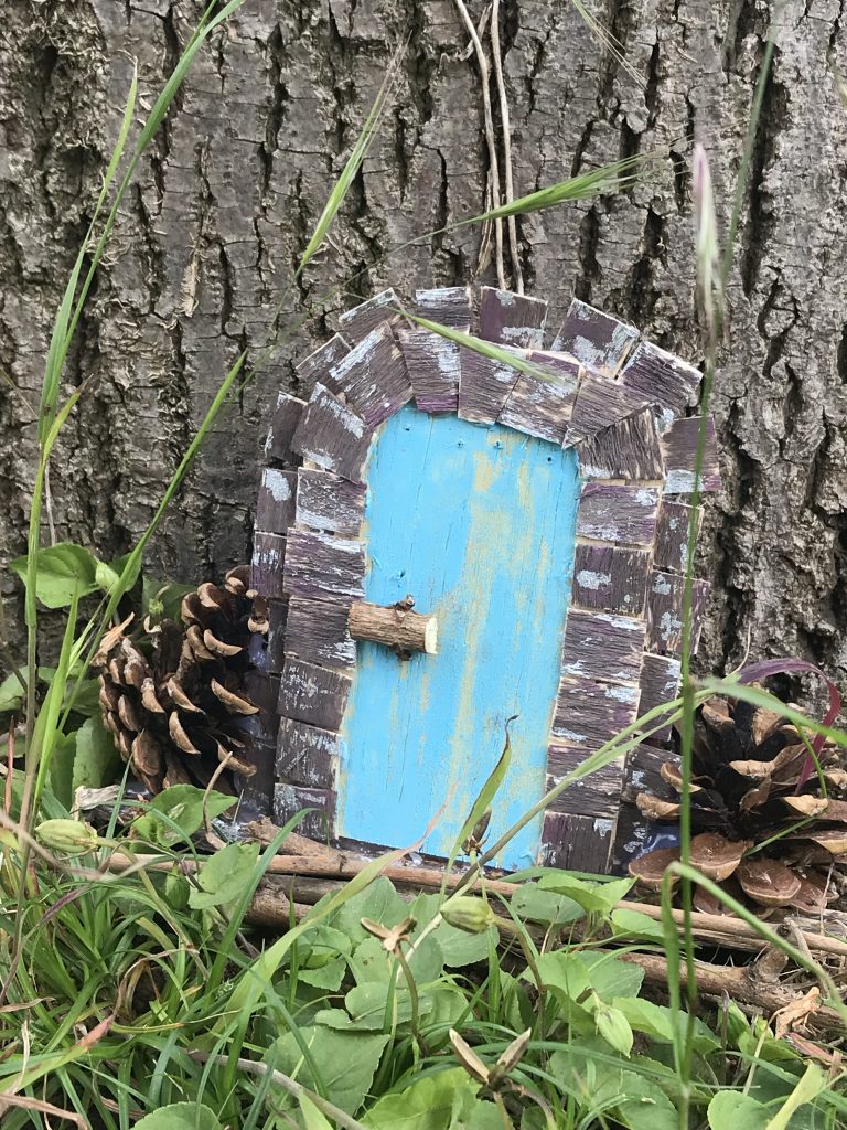 mini-porte en bois au pied d'un arbre