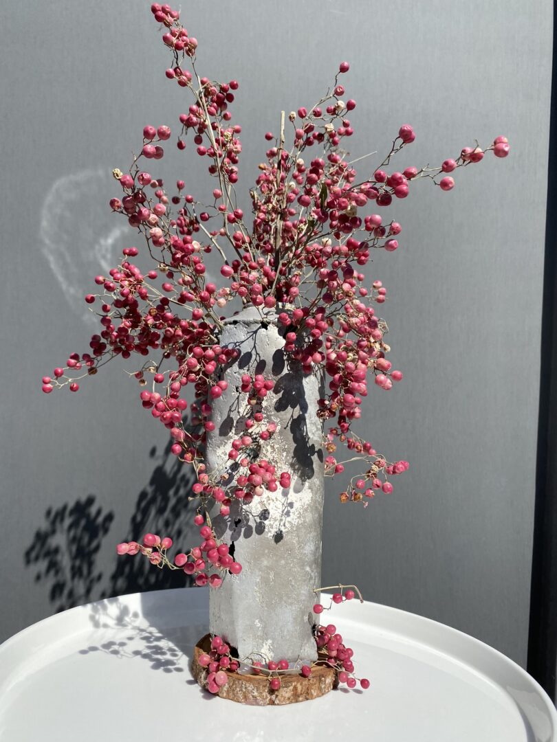 Bombe de peinture détournée en vase qui contient de branches à fruits rouges
