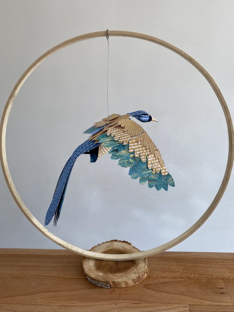 oiseau de papier dans un cercle en bois