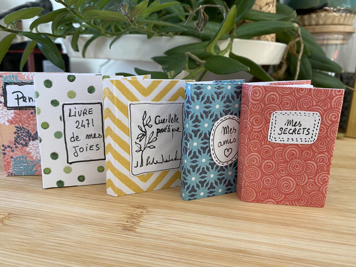 Mini livres fait mains en papier avec différents motifs.