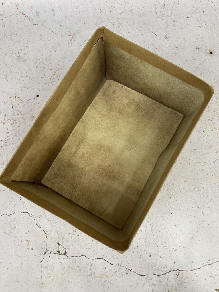 boite carton avec le fond habillé de papier couleur béton sale