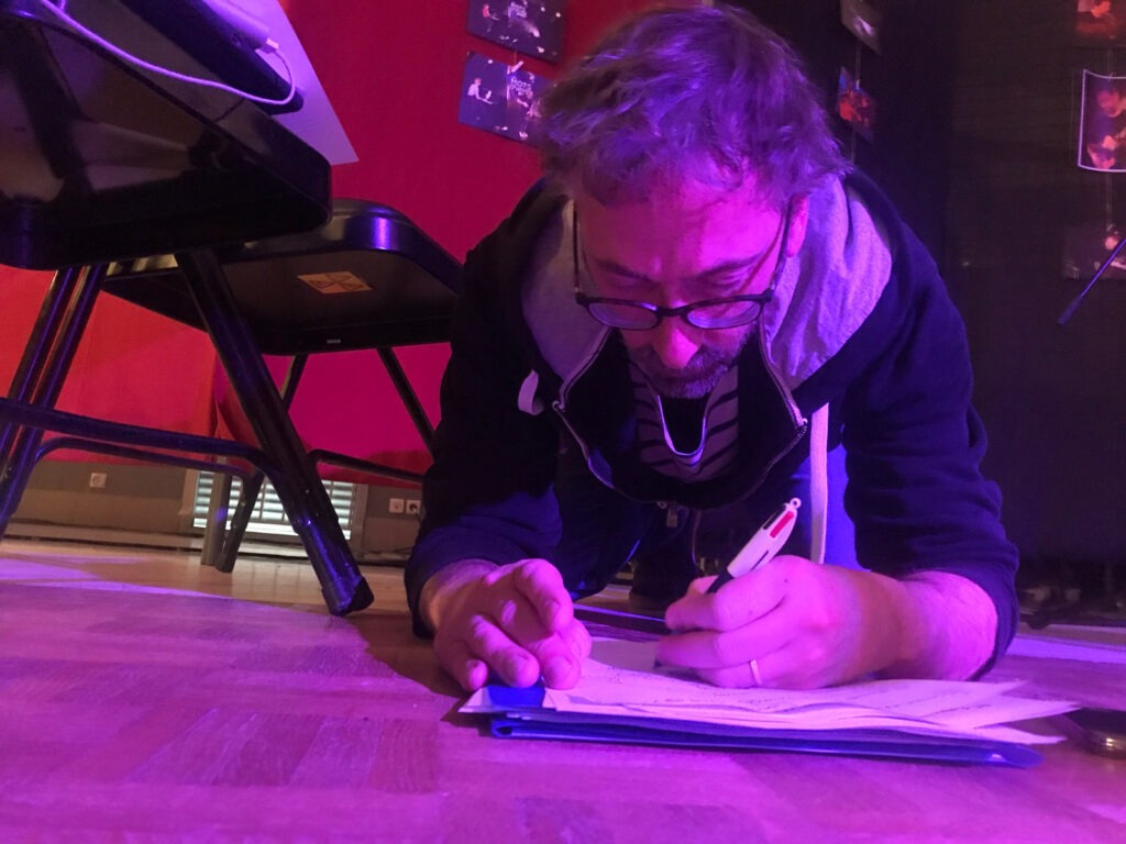 Stage d'écriture de chanson avec les frères Volo 2 Olivier du groupe Volo qui travaille par terre. On peut voir 2 chaises à côté de lui.