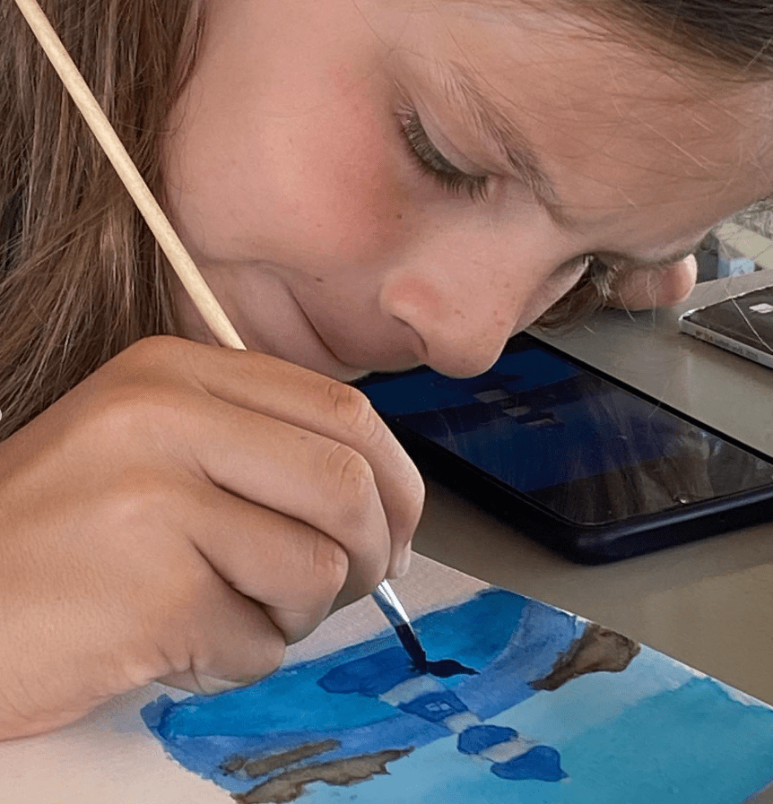 fille concentrée qui peint en aquarelle