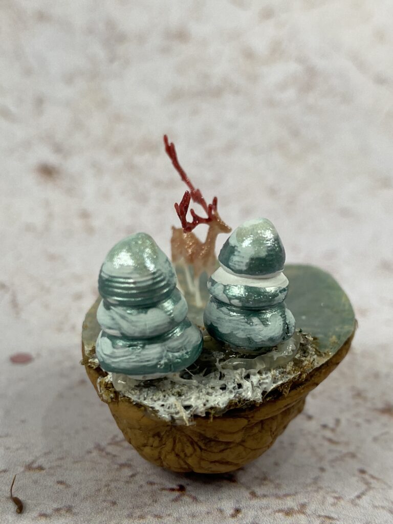 miniatures de cerf et de sapins dans une noix